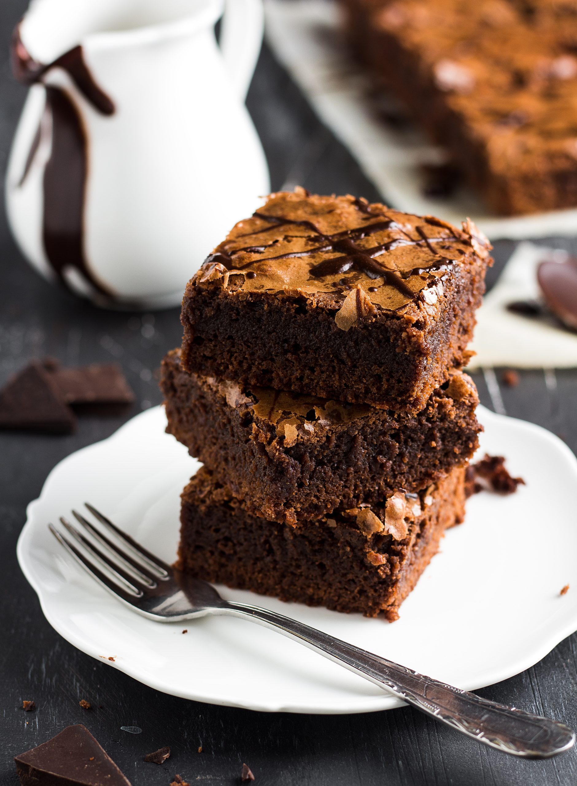 Chocolate brownie cake piece stack on plate homemade pastries sweet cooking with melted chocolate on dark background